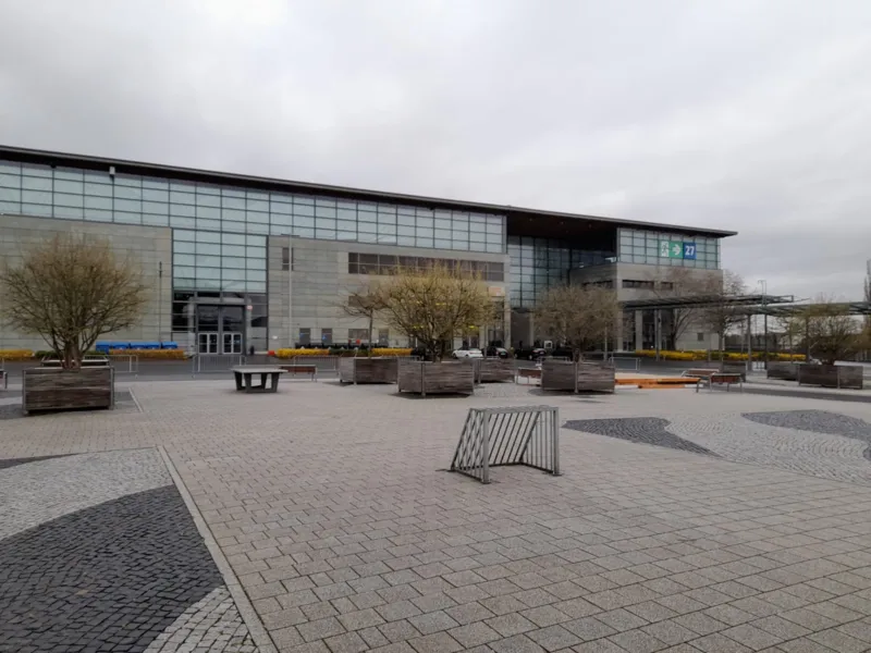 Tore und Tischtennisplatten vor einer Halle.